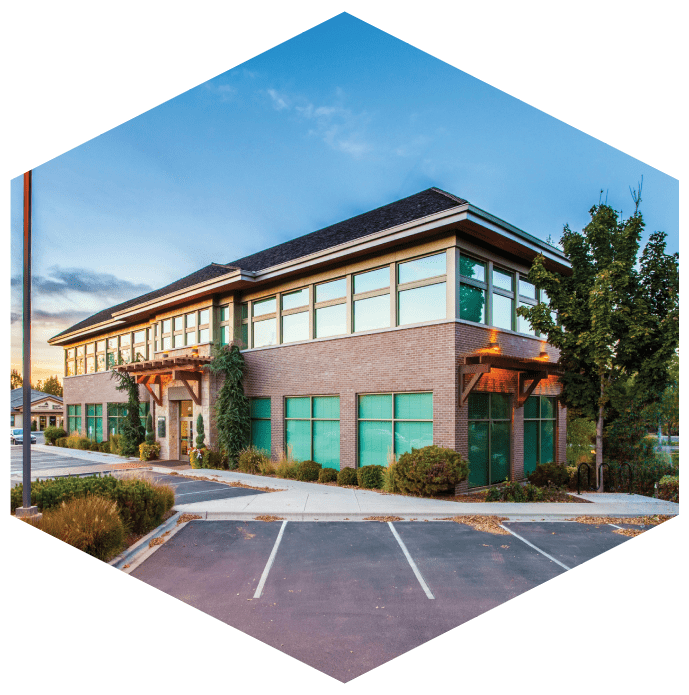 A building with green windows and a parking lot.