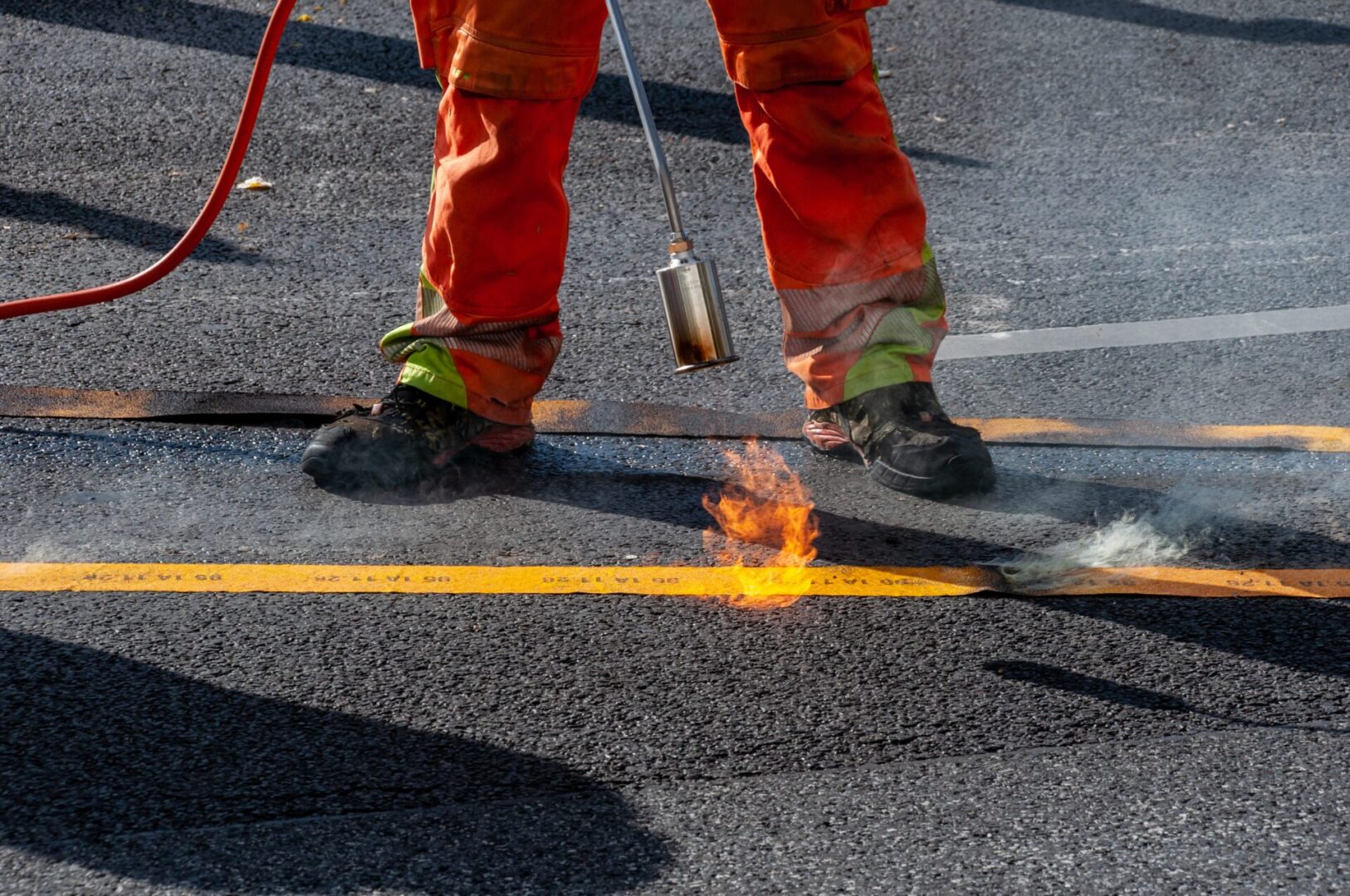 A person in orange pants and red work boots.