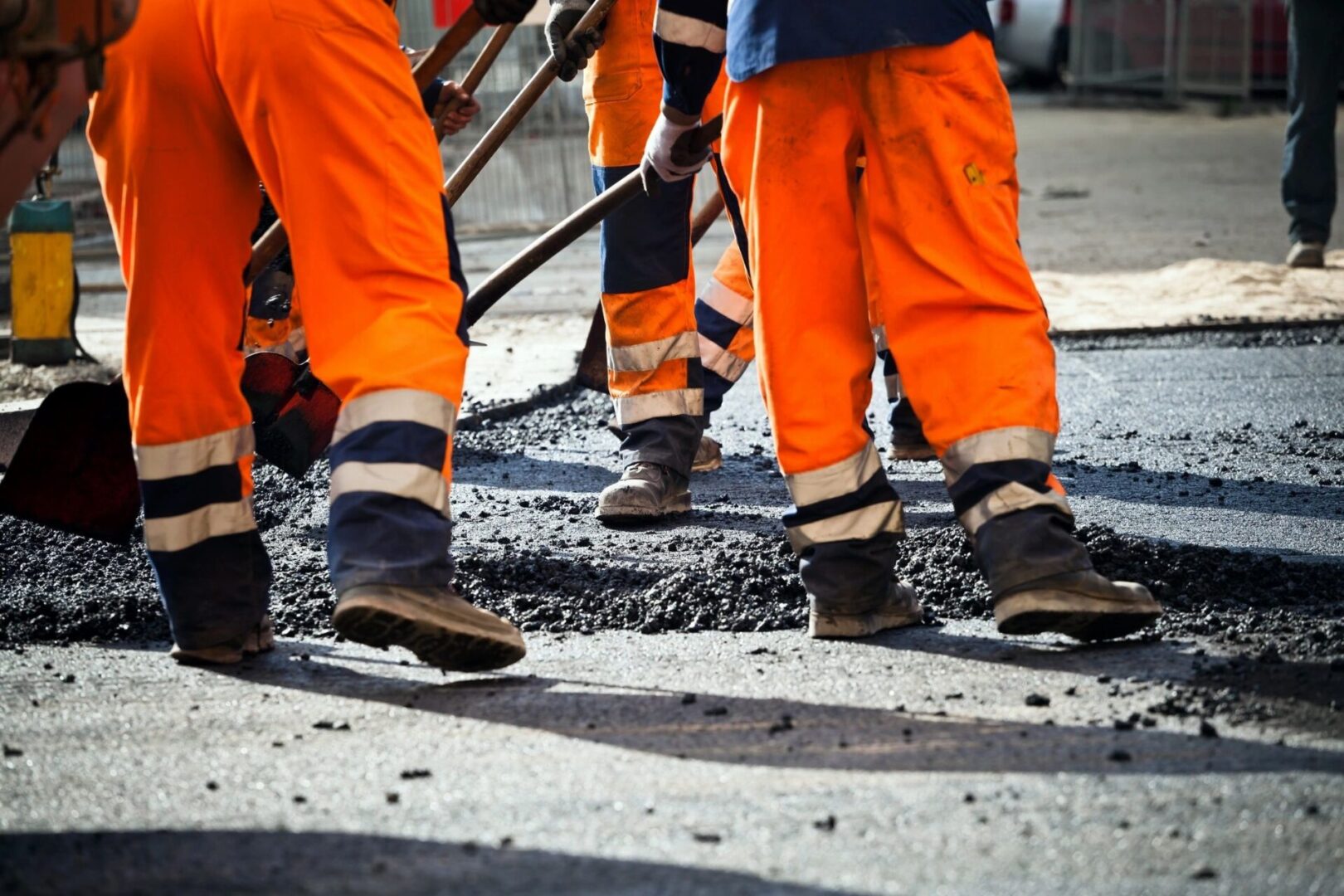 A group of workers are standing on the street.