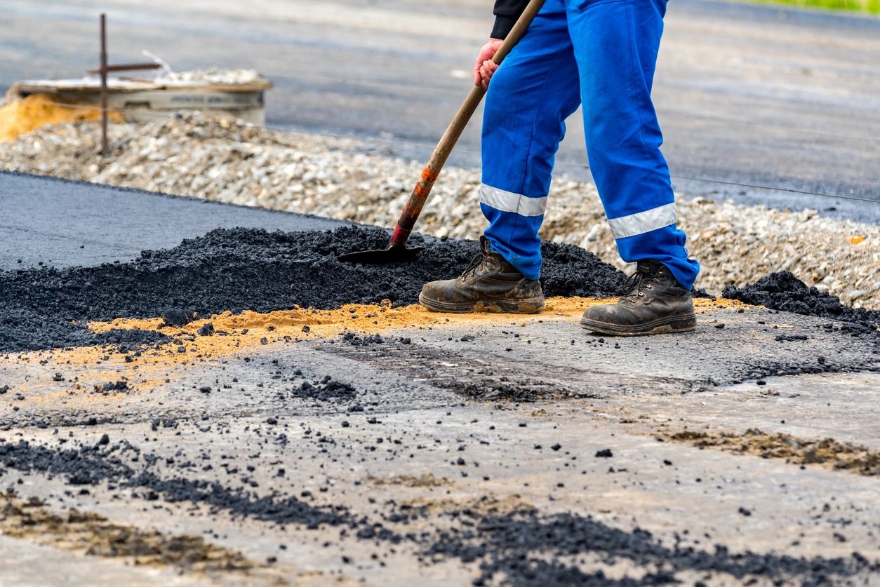 A person with a shovel is standing on the street.